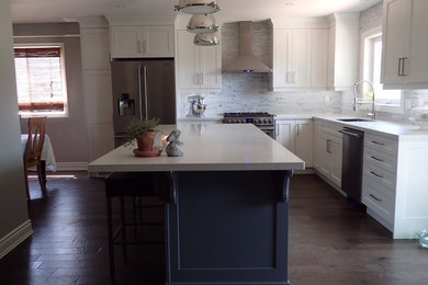 Large transitional l-shaped kitchen photo in Toronto with shaker cabinets, white cabinets, stainless steel appliances and an island