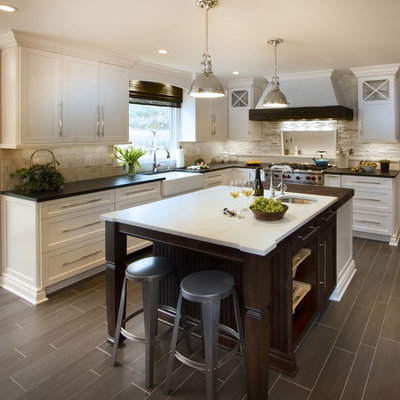 Inspiration for a transitional kitchen remodel in New York with a farmhouse sink, shaker cabinets, white cabinets, marble countertops, white backsplash, stone tile backsplash and stainless steel appliances