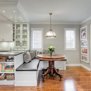 Idee per una cucina abitabile chic con lavello sottopiano, ante con riquadro incassato, elettrodomestici bianchi e pavimento in legno massello medio