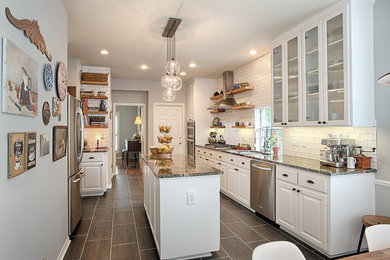 Eat-in kitchen - mid-sized traditional single-wall eat-in kitchen idea in Austin with an undermount sink, raised-panel cabinets, white cabinets, white backsplash, subway tile backsplash, stainless steel appliances and an island