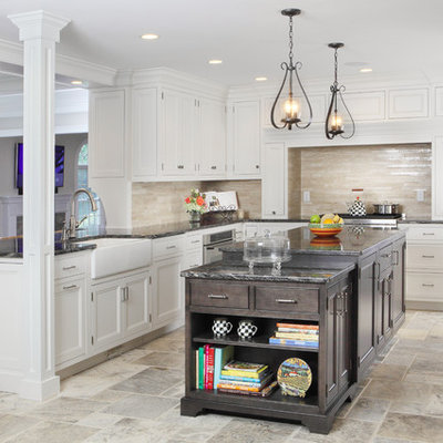 Eat-in kitchen - large transitional l-shaped travertine floor eat-in kitchen idea in New York with beaded inset cabinets, a farmhouse sink, granite countertops, white cabinets, beige backsplash, an island, stainless steel appliances and travertine backsplash