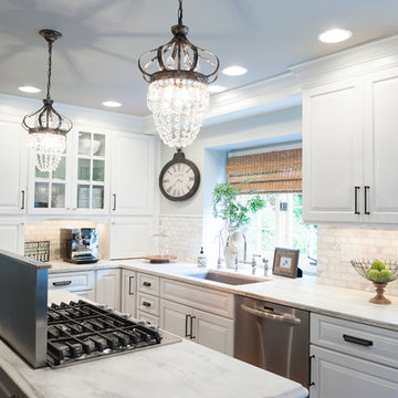 Transitional white kitchen with gray island that incorporates a downdraft vent