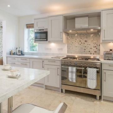 Transitional white kitchen with grey glass backsplash