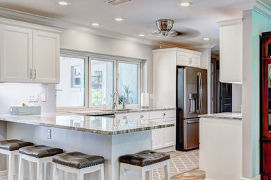Mid-sized transitional porcelain tile kitchen photo in Tampa with recessed-panel cabinets, white cabinets, granite countertops and a peninsula