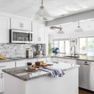 Inspiration for a huge contemporary u-shaped medium tone wood floor and brown floor kitchen remodel in Providence with a single-bowl sink, recessed-panel cabinets, white cabinets, granite countertops, gray backsplash, marble backsplash, stainless steel appliances, an island and gray countertops