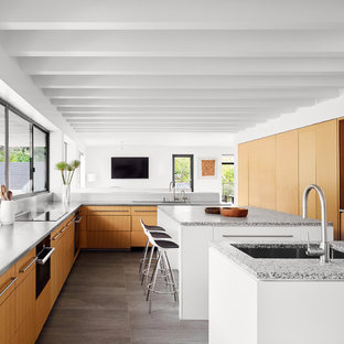 Contemporary open concept kitchen ideas - Example of a trendy l-shaped gray floor open concept kitchen design in Austin with an undermount sink, flat-panel cabinets, medium tone wood cabinets, window backsplash, paneled appliances, two islands and gray countertops