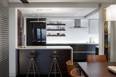 Modelo de cocina comedor actual con armarios con paneles lisos, puertas de armario negras y electrodomésticos negros