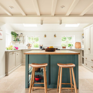 Design ideas for a medium sized rural u-shaped kitchen in Cardiff with shaker cabinets, beige cabinets, integrated appliances, porcelain flooring, an island, beige floors and beige worktops.