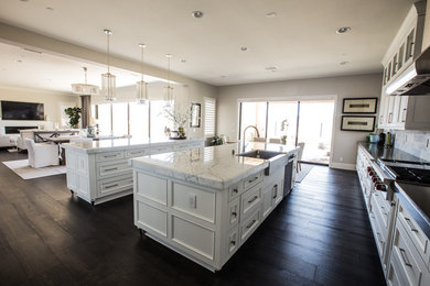 Inspiration for a large contemporary dark wood floor eat-in kitchen remodel in Orange County with a drop-in sink, white cabinets and two islands