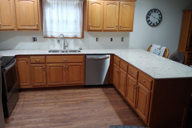 Inspiration for a mid-sized timeless u-shaped vinyl floor and brown floor eat-in kitchen remodel in Other with an undermount sink, raised-panel cabinets, medium tone wood cabinets, quartz countertops, stainless steel appliances, a peninsula and beige countertops