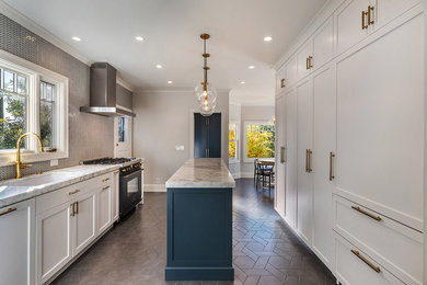 Inspiration for a mediterranean porcelain tile and gray floor eat-in kitchen remodel in San Francisco with an undermount sink, shaker cabinets, white cabinets, marble countertops, white backsplash, marble backsplash, black appliances, an island and white countertops
