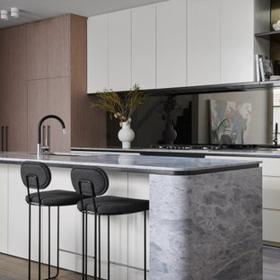 Mid-sized contemporary galley kitchen in Melbourne with a single-bowl sink, flat-panel cabinets, medium wood cabinets, black splashback, glass sheet splashback, panelled appliances, medium hardwood floors, with island, brown floor and grey benchtop.