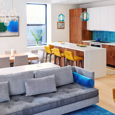 Open concept kitchen - contemporary galley light wood floor and beige floor open concept kitchen idea in New York with flat-panel cabinets, medium tone wood cabinets, blue backsplash, paneled appliances and an island