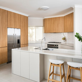 Mid-sized contemporary l-shaped eat-in kitchen in Perth with a double-bowl sink, flat-panel cabinets, grey cabinets, quartz benchtops, white splashback, subway tile splashback, stainless steel appliances, ceramic floors, with island, beige floor and white benchtop.