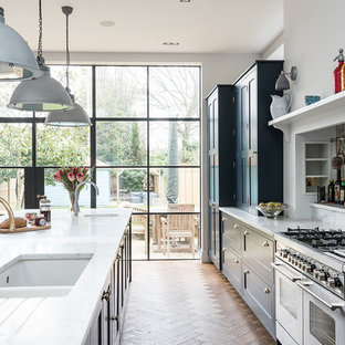 Ispirazione per una grande cucina classica con ante in stile shaker, ante blu, top in marmo, elettrodomestici da incasso, pavimento in legno massello medio, isola e lavello sottopiano