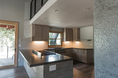 Example of a mid-sized urban u-shaped medium tone wood floor eat-in kitchen design in Other with a farmhouse sink, shaker cabinets, gray cabinets, quartzite countertops, stainless steel appliances and an island