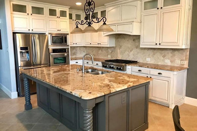 Eat-in kitchen - mid-sized traditional l-shaped ceramic tile and beige floor eat-in kitchen idea in Dallas with a double-bowl sink, raised-panel cabinets, white cabinets, granite countertops, beige backsplash, ceramic backsplash, stainless steel appliances and an island