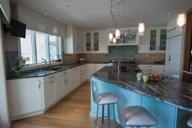 Imagen de cocina minimalista con puertas de armario blancas, encimera de granito, salpicadero multicolor, electrodomésticos de acero inoxidable y península