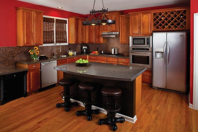 Idéer för att renovera ett stort vintage kök, med en undermonterad diskho, luckor med upphöjd panel, skåp i mellenmörkt trä, bänkskiva i kvarts, brunt stänkskydd, stänkskydd i glaskakel, rostfria vitvaror, ljust trägolv och en köksö