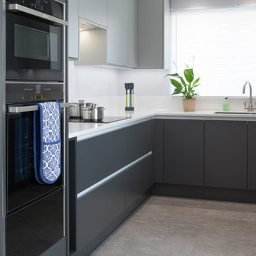 True handless monochrome  panel door kitchen with Corian worktop