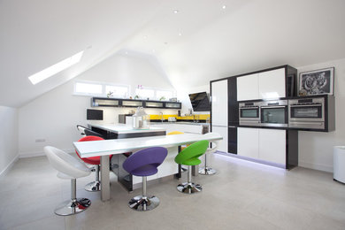 Moderne Küche mit flächenbündigen Schrankfronten, Küchenrückwand in Gelb und Küchengeräten aus Edelstahl in Cornwall