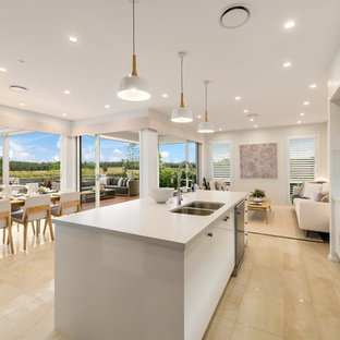 Inspiration for a large beach style galley open plan kitchen in Sydney with an undermount sink, flat-panel cabinets, light wood cabinets, quartz benchtops, window splashback, stainless steel appliances, ceramic floors, with island and yellow floor.