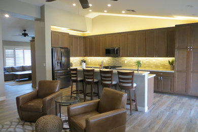 Example of a mid-sized trendy l-shaped porcelain tile and brown floor open concept kitchen design in Phoenix with a double-bowl sink, shaker cabinets, medium tone wood cabinets, quartz countertops, beige backsplash, glass tile backsplash, stainless steel appliances, an island and white countertops
