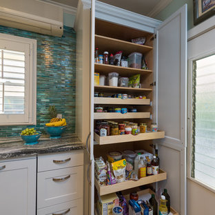 This is an example of a mid-sized tropical separate kitchen in Hawaii with an undermount sink, shaker cabinets, white cabinets, quartzite benchtops, blue splashback, glass tile splashback, panelled appliances, vinyl floors, no island and grey floor.