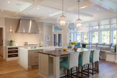 Inspiration for a large transitional single-wall light wood floor eat-in kitchen remodel in Miami with a farmhouse sink, flat-panel cabinets, beige cabinets, granite countertops, beige backsplash, glass tile backsplash, stainless steel appliances and an island