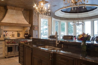 Mid-sized tuscan l-shaped travertine floor eat-in kitchen photo in Cleveland with a double-bowl sink, recessed-panel cabinets, an island, beige cabinets, solid surface countertops and paneled appliances