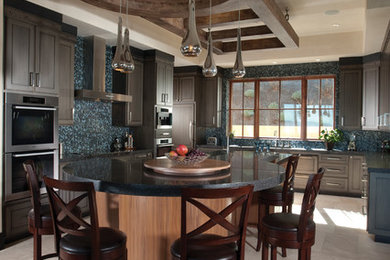 Bild på ett mellanstort medelhavsstil kök, med en nedsänkt diskho, luckor med infälld panel, skåp i mellenmörkt trä, marmorbänkskiva, flerfärgad stänkskydd, stänkskydd i mosaik, rostfria vitvaror, klinkergolv i keramik och en köksö