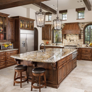 Kitchen - mediterranean u-shaped beige floor kitchen idea in Houston with an undermount sink, raised-panel cabinets, dark wood cabinets, beige backsplash, an island and beige countertops