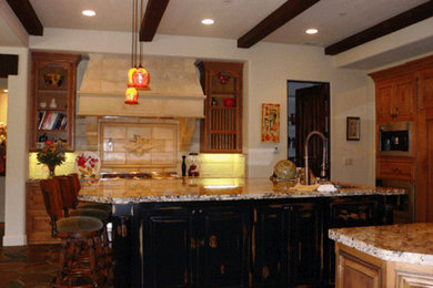Example of a terra-cotta tile kitchen pantry design in San Francisco with an undermount sink, raised-panel cabinets, medium tone wood cabinets, granite countertops, beige backsplash, ceramic backsplash, stainless steel appliances and a peninsula