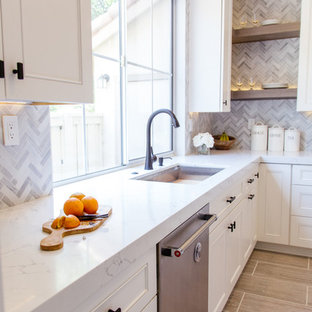 Mid-sized contemporary eat-in kitchen ideas - Eat-in kitchen - mid-sized contemporary l-shaped porcelain tile and gray floor eat-in kitchen idea in Orange County with an undermount sink, shaker cabinets, white cabinets, marble countertops, gray backsplash, an island, mosaic tile backsplash and stainless steel appliances