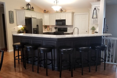 Example of a mid-sized transitional u-shaped laminate floor open concept kitchen design in St Louis with recessed-panel cabinets, gray cabinets, quartz countertops, gray backsplash, glass tile backsplash and a peninsula