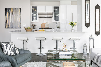 Contemporary open plan kitchen in Boston with glass-front cabinets, white cabinets and white splashback.