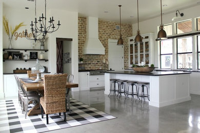 Example of a large cottage u-shaped concrete floor kitchen design in Austin with white cabinets, subway tile backsplash, an island and black countertops
