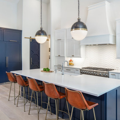 Inspiration for a large transitional u-shaped light wood floor and beige floor eat-in kitchen remodel in Austin with a farmhouse sink, white backsplash, an island, white countertops, quartzite countertops, ceramic backsplash, recessed-panel cabinets, white cabinets and paneled appliances