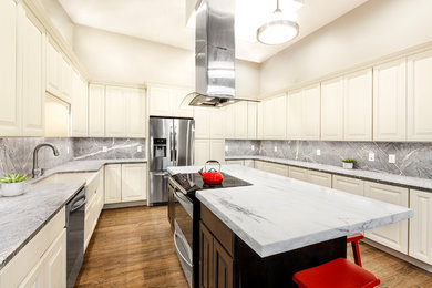 Example of a large minimalist u-shaped vinyl floor eat-in kitchen design in Boston with a farmhouse sink, raised-panel cabinets, white cabinets, marble countertops, gray backsplash, stone slab backsplash, stainless steel appliances and an island