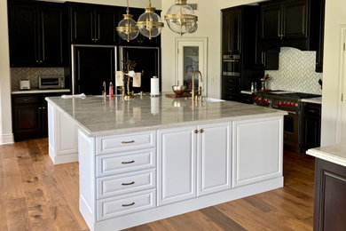 Elegant u-shaped kitchen photo in Orange County with raised-panel cabinets, white cabinets, beige backsplash, subway tile backsplash, black appliances and an island