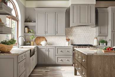 Mid-sized transitional l-shaped ceramic tile and multicolored floor eat-in kitchen photo in Detroit with a farmhouse sink, recessed-panel cabinets, gray cabinets, granite countertops, metallic backsplash, marble backsplash, stainless steel appliances, an island and multicolored countertops