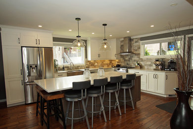 Mid-sized mountain style galley medium tone wood floor and brown floor eat-in kitchen photo in Other with an undermount sink, recessed-panel cabinets, white cabinets, quartzite countertops, multicolored backsplash, slate backsplash, stainless steel appliances, an island and white countertops