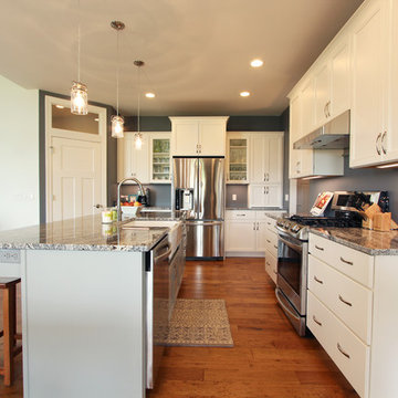 Two Toned Kitchen with White Cabinets on Perimeter and a Gray Island