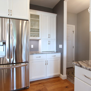 Two Toned Kitchen with White Cabinets on Perimeter and a Gray Island