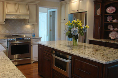 Example of a classic l-shaped eat-in kitchen design in Boston with raised-panel cabinets, beige cabinets and stainless steel appliances