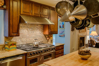 Elegant single-wall eat-in kitchen photo in Charlotte with medium tone wood cabinets, multicolored backsplash, stone slab backsplash and stainless steel appliances