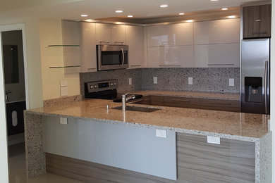 Small minimalist u-shaped enclosed kitchen photo in Miami with an integrated sink, flat-panel cabinets, white cabinets, marble countertops, gray backsplash, stainless steel appliances and beige countertops