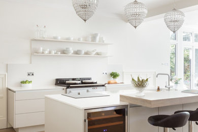 Inspiration for a large contemporary u-shaped kitchen in Hertfordshire with an integrated sink, flat-panel cabinets, white cabinets, composite countertops, white splashback and light hardwood flooring.