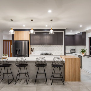Inspiration for a large contemporary galley kitchen pantry in Other with a drop-in sink, flat-panel cabinets, white cabinets, granite benchtops, white splashback, subway tile splashback, black appliances, ceramic floors, with island, grey floor and white benchtop.