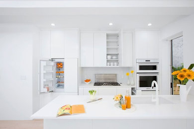 Kitchen - modern beige floor kitchen idea in New York with white backsplash, white appliances and white countertops